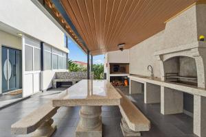 an outdoor kitchen with a stone table and a fireplace at Florentina Villa in Gaula