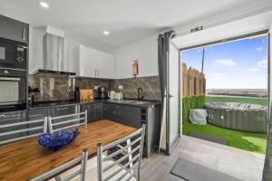 a kitchen and dining room with a large sliding glass door at Casa da Telvina in Paul do Mar