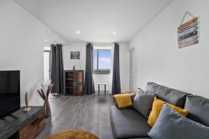 a living room with a couch and a tv at Casa da Telvina in Paul do Mar