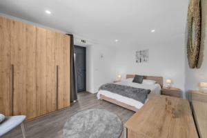 a bedroom with a bed and a wooden cabinet at Casa da Telvina in Paul do Mar