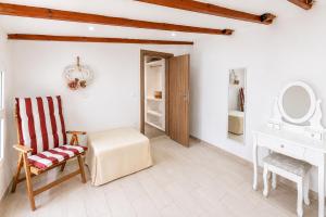 a bathroom with a chair and a table and a mirror at Cavo Prima Kiotari in Gennadi