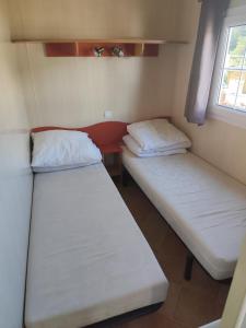 two beds in a small room with a window at San gavino in Savines