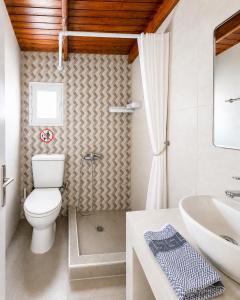 a bathroom with a toilet and a sink at Cavo Prima Kiotari in Gennadi +16 photos