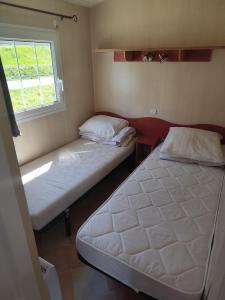 two beds in a small room with a window at San gavino in Savines