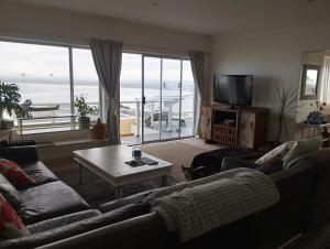 a living room with a couch and a table and a television at Sea Echo in Yzerfontein +4 photos
