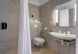 a bathroom with a toilet and a sink at B&B HOTEL Reims Tinqueux in Reims +25 photos