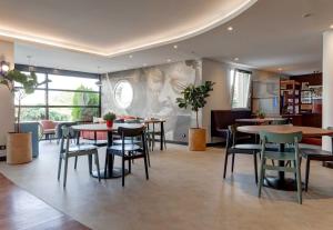 a restaurant with tables and chairs in a room at B&B HOTEL Reims Tinqueux in Reims