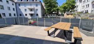 a wooden bench sitting on top of a patio at Siegen Oberstadt mit Küche und 75 Zoll TV - VN in Siegen +5 photos