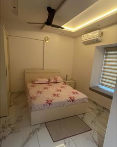 a bedroom with a bed and a ceiling fan at Malhar Homes in Kozhikode +9 photos