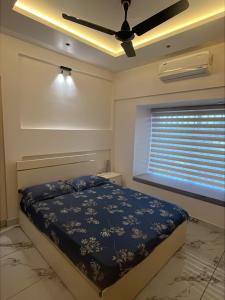 a bedroom with a bed and a ceiling fan at Malhar Homes in Kozhikode
