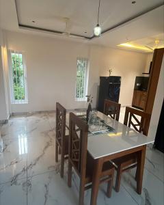 a kitchen and dining room with a table and chairs at Malhar Homes in Kozhikode