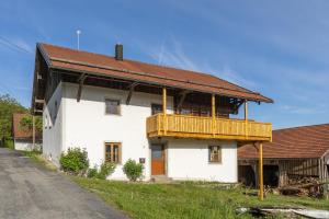 a white house with a wooden balcony on it at Ferienhaus - Großer Büchelstein in Grattersdorf