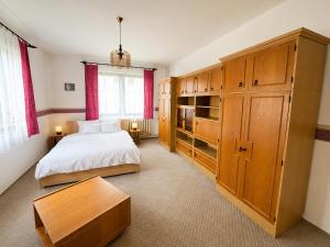 a bedroom with a bed and a wooden cabinet at Retro Land Bogács in Bogács