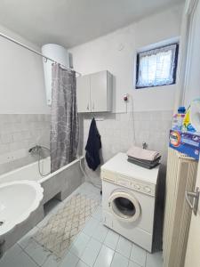 a bathroom with a washing machine and a sink at Retro Land Bogács in Bogács +3 photos