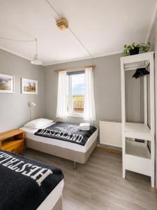 a bedroom with two beds and a window at Hestaland Riverside Cottage in Staðarhús