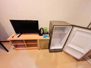 a desk with an open refrigerator next to a desk with a monitor at Silver Oaks Hotel in Patong Beach