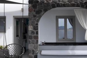 a bathroom with a bath tub and a window at Lumera Suites in Firostefani