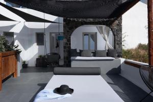 a patio with a table with a hat on it at Lumera Suites in Firostefani