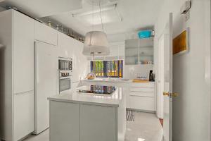 a kitchen with white cabinets and a white counter top at Bungalow meloneras in San Bartolomé