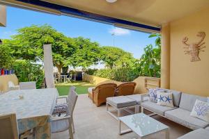 a patio with couches and a table and chairs at Bungalow meloneras in San Bartolomé