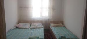 two beds in a small room with a window at House Ali in Klyuchi +4 photos