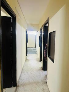 ein Flur mit Türen und eine Person, die in einem Zimmer steht in der Unterkunft Hotel Blueberry - Noida sector 34 Metro in Noida + 17 Fotos