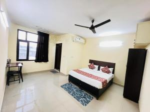 ein Schlafzimmer mit einem Bett und einem Schreibtisch in der Unterkunft Hotel Blueberry - Noida sector 34 Metro in Noida