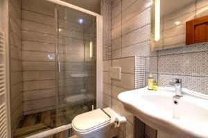 a bathroom with a toilet and a sink and a shower at Apartments Hradný Mur in Bojnice +40 photos