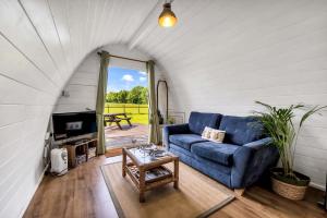 a living room with a blue couch and a table at Dreish - Glamping Pod in Forfar