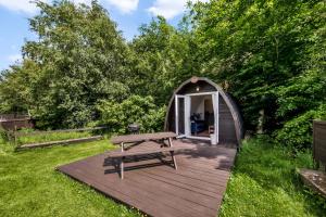 a wooden deck with a picnic table and a gazebo at Dreish - Glamping Pod in Forfar