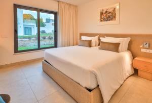 a large bed in a room with a window at Primelife Carvoeiro in Praia do Carvoeiro +53 photos