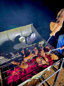 a person is cooking food on a grill at Sinharaja Eco Camp in Deniyaya