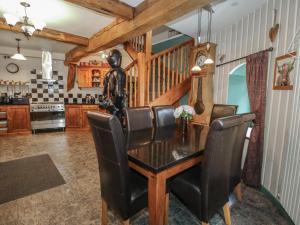 a dining room with a table and black chairs at Hadley Park Windmill in Telford