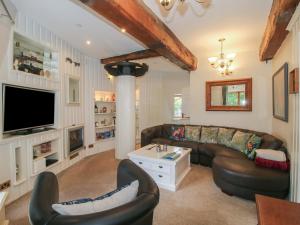 a living room with leather furniture and a tv at Hadley Park Windmill in Telford