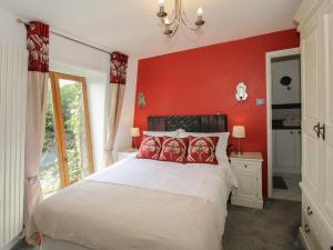 a red bedroom with a white bed and a window at Hadley Park Windmill in Telford