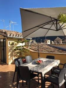 einen Tisch und Stühle mit Sonnenschirm auf einer Terrasse in der Unterkunft Appartamento con terrazza in Via Campo dei Fiori in Spoleto