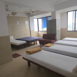a room with several beds and chairs in it at Hotel Sai Leela in Amarnāth