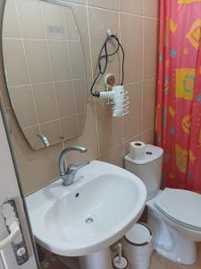 a bathroom with a sink and a toilet and a mirror at Elite Apart Pansiyon in Gokceada Town +55 photos
