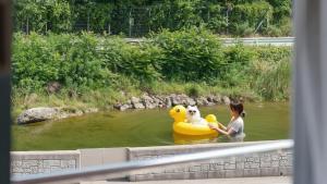 a girl in the water with a yellow rubber duck at Samcheok Healingcamp Pension in Samcheok +2 photos