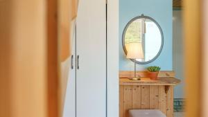 a room with a table with a lamp and a mirror at Samcheok Healingcamp Pension in Samcheok