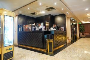 a bar in a hotel with two people standing behind it at Attawfeek Plaza in Tripoli