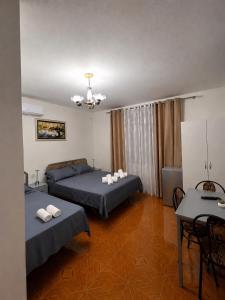 a hotel room with two beds and a table at Alira Rooms in Pogradec