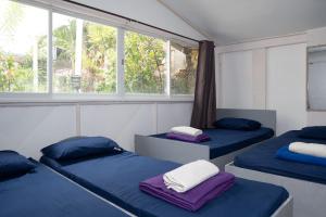 two beds in a room with a window at EnPensionne Hotel in Iloilo City