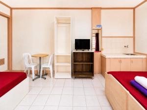 a room with a bed and a kitchen with a television at EnPensionne Hotel in Iloilo City