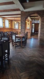 a dining room with tables and chairs and a brick wall at Crama Tărănească in Tătărani +5 photos