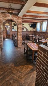 a restaurant with tables and chairs and a brick wall at Crama Tărănească in Tătărani