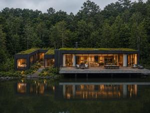 a house with a green roof on the water at De Holiday Home in Haenertsburg