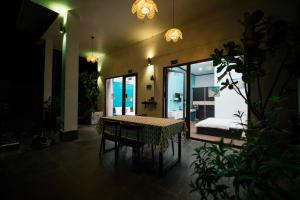 a dining room with a table and chairs in a room at Coto Center Homestay in Đảo Cô Tô