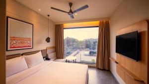a hotel room with a bed and a large window at 7 Apple Hotel Visakhapatnam in Visakhapatnam +35 photos