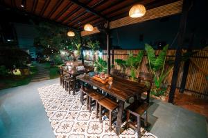 a dining room with wooden tables and chairs on a patio at Coto Center Homestay in Đảo Cô Tô